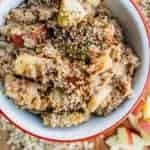 A bowl of oatmeal with apples and seeds mixed in