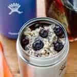 Oatmeal topped with blueberries inside a insulated food jar